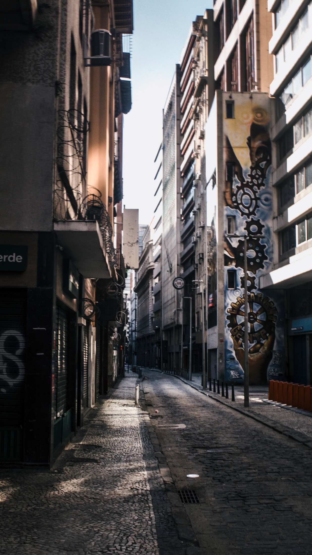 Quiet narrow street showcasing urban architecture and street art